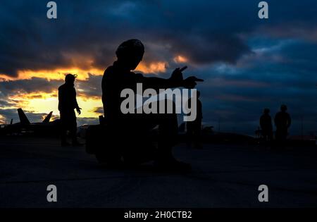 L'Airman de la Marine américaine Steven Savala, ordnanceman de l'aviation affecté à l'escadron d'attaque électronique (VAQ) 132 de la base aérienne de Whidbey Island, Washington, signale un growler EA-18G pendant le Red Flag 21-1 à la base aérienne de Nellis, Nevada, le 26 janvier 2021.La Marine participe au Red Flag 21-1 en tant que partenaire conjoint de la U.S. Air Force. Banque D'Images