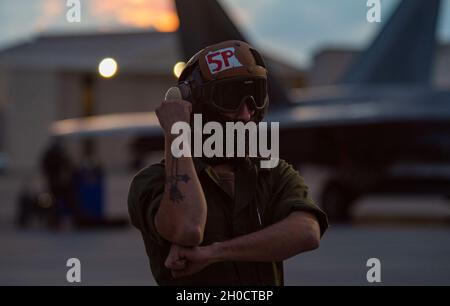 L'Airman de la Marine américaine Steven Savala, ordnanceman de l'aviation affecté à l'escadron d'attaque électronique (VAQ) 132 de la base aérienne de Whidbey Island, Washington, signale un growler EA-18G pendant le Red Flag 21-1 à la base aérienne de Nellis, Nevada, le 26 janvier 2021.La Marine participe au Red Flag 21-1 en tant que partenaire conjoint de la U.S. Air Force. Banque D'Images