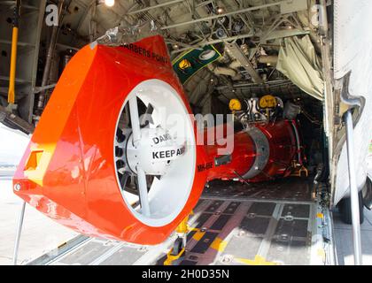 Un hélicoptère Dolphin de la station aérienne de la Garde côtière Barbers point MH-65E arrive à bord d'un avion Hercules HC-130 à Oahu, à Hawaï, le 28 janvier 2021.L'hélicoptère est un nouveau modèle d'écho avec des améliorations allant de l'amélioration du radar météorologique/de surface numérique à la modernisation de l'avionique du précédent modèle « delta ». Banque D'Images