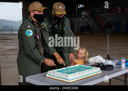 Cmdr. Marine américaineSteven D. Hacker(à gauche), commandant en sortie, Escadron de soutien logistique de la flotte américaine 51, et Cmdr.Joshua J. Lostetter(à droite), commandant à venir, VR-51, a coupé le gâteau après une cérémonie de changement de commandement, Marine corps Air Station Kaneohe Bay, Marine corps base Hawaii, 28 janvier 2021. Banque D'Images