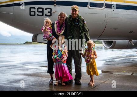 Cmdr. Marine américaineJoshua J. Lostetter, commandant à venir, US Navy Fleet Logistics support Squadron 51, pose pour une photo de famille après une cérémonie de changement de commandement, Marine corps Air Station Kaneohe Bay, Marine corps base Hawaii, le 28 janvier 2021.Pendant la cérémonie, U.S. Navy Cmdr.Steven D. Hacker, commandant en exercice, VR-51, a abandonné le commandement à Lostetter. Banque D'Images