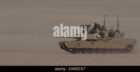 Soldats de l'armée américaine, 1er Bataillon, 6e Régiment d'infanterie, 2e Brigade combat Team, 1re Division d'armure, dirige un char M1 Abrams vers une simulation de braconnage d'une position ennemie lors d'un exercice d'entraînement situationnel, le 31 janvier 2021, à Iron Union 14 au Centre d'entraînement Al Hamra aux Émirats arabes Unis.Des événements comme Iron Union développent des partenariats militaires-à-militaires en permettant aux soldats de l'armée de terre des États-Unis et des Forces terrestres des Émirats arabes Unis d'apprendre les tactiques, les techniques et les procédures d'un partenaire clé et d'accroître leur état de préparation et leur interopérabilité. Banque D'Images