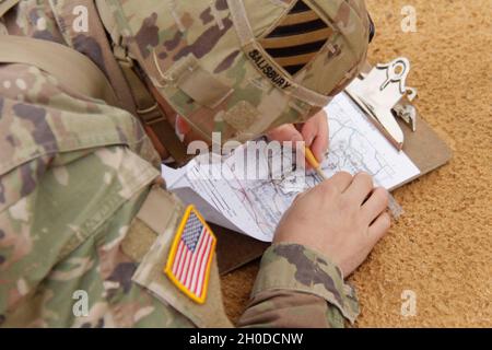 Un soldat affecté au 1er Bataillon de la Force opérationnelle, 28e Régiment d'infanterie, 3e Division d'infanterie, trace des points sur une carte lors d'une évaluation de la navigation terrestre pour l'insigne d'infanterie d'experts à fort Benning (Géorgie), le 2 février 2021.Les soldats sont tenus d'apporter une boussole, un rapporteur, un instrument d'écriture, et ils sont fournis une carte, une échelle de coordonnées, une feuille de scores et les points désignés. Banque D'Images