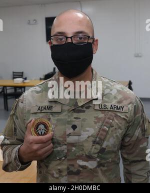 Un soldat de l'armée américaine de Bravo Battery, 5e Bataillon, 52e Régiment d'artillerie de défense aérienne, détient une pièce de la Force opérationnelle Spartan qu'il a reçue du commandant du TFS Patrick Hamilton, le 3 février 2021, à la base aérienne Al Dhafra, dans les Émirats arabes Unis.Les soldats ont reçu les pièces pour avoir dépassé les normes de l'Armée de terre et ont fait preuve d'initiative lors du déploiement à l'appui de la sécurité des opérations et du renforcement des partenariats dans la zone d'opération de l'Asie du Sud-Ouest. Banque D'Images