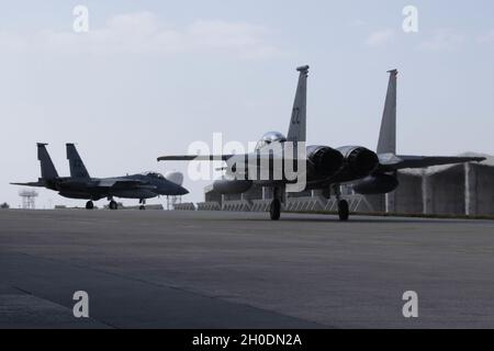 Deux pilotes de chasse de la US Air Force, du 44e Escadron de chasseurs, taxi F-15C Eagles pour prendre le COPE North 21 de la base aérienne de Kadena, au Japon, le 4 février 2021.Cope North 21 est un exercice d'entraînement trilatéral entre les forces aériennes américaines, japonaises et australiennes visant à développer des capacités de combat et à améliorer la supériorité aérienne, la guerre électronique, l'interdiction aérienne, le transport aérien tactique et le ravitaillement en carburant aérien. Banque D'Images