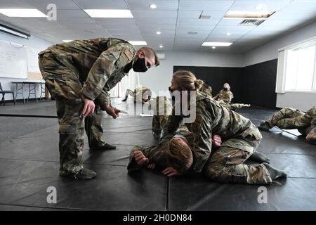 Membres du 119e Escadron de sécurité Sgt.Lacey Bunkelman, un instructeur combatifs, à gauche, enseigne les techniques combatives d'autodéfense au Sgt maître.Kellynn Zinck, top, et Tech.Sgt.Evan Newman au Centre régional de formation à l'application de la loi de Fargo, Fargo, N.D., 3 février 2021.Les techniques de combat sont destinées à être utilisées pour dominer les attaquants rencontrés pendant leur service à la base de la Garde nationale aérienne du Dakota du Nord ou dans tout autre lieu de service. Banque D'Images