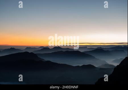 quelques instants avant le lever du soleil sur le sommet d'une montagne qui donne sur les sommets des alpes bavaroises et autrichiennes avec du brouillard dans les vallées Banque D'Images