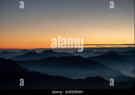 quelques instants avant le lever du soleil sur le sommet d'une montagne qui donne sur les sommets des alpes bavaroises et autrichiennes avec du brouillard dans les vallées Banque D'Images