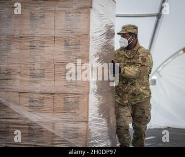 Sergent d'état-major de la Force aérienne des États-UnisMelbourne Foster, 103e Escadron de génie civil, prépare les agriculteurs du département américain de l'Agriculture aux familles des boîtes alimentaires pour distribution au champ Rentschler à East Hartford, Connecticut, le 4 février 2021.Des aviateurs de la 103e Escadre de transport aérien de la Garde nationale du Connecticut soutiennent des opérations logistiques sur le site de distribution d’urgence du drive de FoodShare, qui a distribué plus de 8,000,000 livres de nourriture à 233,000 voitures depuis le 20 avril 2020. Banque D'Images