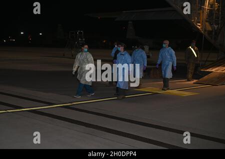 Le personnel médical de la Force aérienne des États-Unis affecté à la 86e escadre du pont aérien escorte un patient COVID-19 d'un avion Super Hercules C-130J de la Force aérienne des États-Unis à la base aérienne de Ramstein, en Allemagne, le 4 février 2021.C'est la première fois que le personnel de la 86e AW a effectué un mouvement de patient Conex-Lite sous pression négative.Le NPC-L s'intègre dans un C130J et est conçu pour transporter des personnes atteintes de COVID-19 ou d'autres maladies hautement infectieuses sans exposer l'équipage et les équipes médicales à bord. Banque D'Images