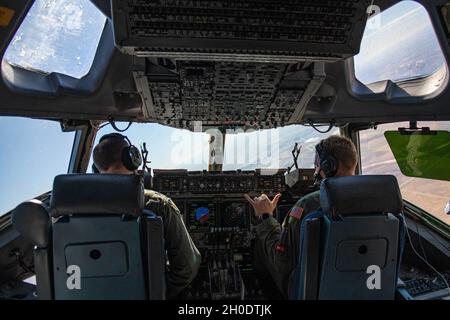 De gauche à droite, le colonel Matthew Leard de la U.S. Air Force, 97e commandant de l'aile Air Mobility, et le lieutenant-colonel Peter McClellan, 97e directeur de l'état-major des agences de l'escadre, pilote un C-17 Globemaster III dans les cieux de l'Oklahoma, le 4 février 2021.Pendant le vol, le Dr Rigsby a été présenté comme véhicule de ravitaillement aérien de première main, de manoeuvres de vol de bas niveau et de déchargement de la cargaison. Banque D'Images