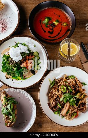 La table est servie avec une variété de plats asiatiques.Soupe. Salade. Plat chaud. Dessert. Banque D'Images