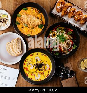 La table est servie avec une variété de plats asiatiques.Soupe. Salade. Plat chaud. Dessert. Banque D'Images