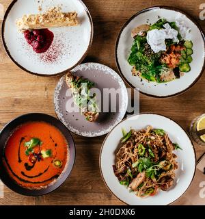 La table est servie avec une variété de plats asiatiques.Soupe. Salade. Plat chaud. Dessert. Banque D'Images