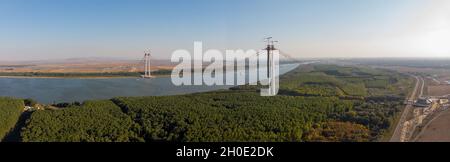 Vue panoramique de drone aérienne depuis le dessus du pont suspendu sur le danube, en construction, entre les villes de Braila et Tulcea en Roumanie Banque D'Images