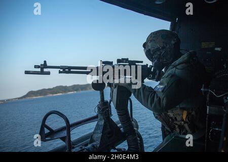 Caporal du corps des Marines des États-UnisLuis Gann, un CHEF d'équipage UH-1Y Huey du Marine Medium Tiltrotor Squadron 262 (renforcé), 31e Marine Expeditionary Unit (MEU), se prépare à tirer son mitrailleuse M240B au-dessus de la portée Whiskey 174, en mer des Philippines, le 6 février 2021.Le 31e MEU opère à bord des navires du groupe de grève expéditionnaire américain dans la zone d'opérations de la 7e flotte afin d'améliorer l'interopérabilité avec les alliés et les partenaires et de servir de force de réaction prête à défendre la paix et la stabilité dans la région Indo-Pacifique. Banque D'Images