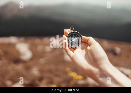 La main de voyageur tient une boussole sur la belle vue des montagnes Carpathian au soleil.Bannière horizontale avec place pour le texte.Vacances et voyages. Banque D'Images