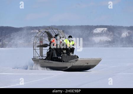 Le U.S. Army corps of Engineers, les techniciens de St. Paul District Survey Dan Devaney, à gauche, et Bill Chelmowski se mettent à bord d'un hydroglisseur au-dessus de la glace au lac Pepin, près de la Red Wing, Minnesota, le 9 février.Le lac fait partie du fleuve Mississippi supérieur.L'équipe recueillait des mesures de glace pour aider l'industrie de la navigation à déterminer quand il est sécuritaire de briser la glace et de commencer la saison de navigation 2021.Les mesures de glace sont recueillies au lac Pepin parce que le débit d'eau est plus lent dans cette région et que la glace est habituellement la plus épaisse.Les responsables de la navigation attendent généralement jusqu'à ce que la glace ne dépasse pas 12 pouces Banque D'Images