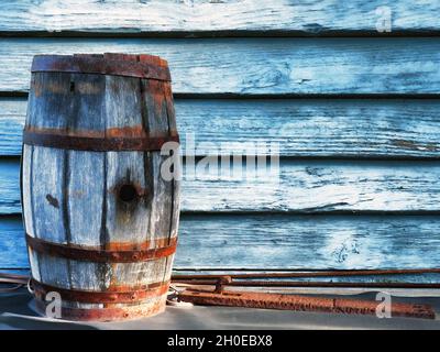 Ancien canon en chêne devant un mur en bois peint bleu Banque D'Images