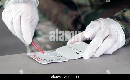 SPC.Alejandra Casillas, un testeur affecté à la Force opérationnelle Viper, 5e Brigade blindée, première division de l'Armée de terre Ouest, insère un échantillon d'écouvillon nasal dans une carte d'essai lors d'un test de carte BinaxNOW COVID-19 AG à fort Bliss, Texas, le 10 février 2021.Les soldats affectés à TF Viper ont administré le test comme moyen d'atténuer la propagation du COVID-19 et de maintenir leur état de préparation puisque le 5e AR BDE continue de fournir une formation solide, réaliste et pertinente basée sur les tactiques, techniques et procédures les plus récentes pour préparer les unités au déploiement dans leurs emplacements spécifiques. Banque D'Images