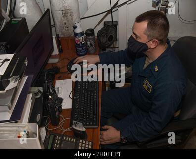 210211-N-DQ752-1008 MER DES PHILIPPINES (FÉV11, 2021) le technicien en chef des systèmes d'information David Hutto, d'Enterprise, en Alabama, gère les comptes informatiques à bord du porte-avions USS Nimitz (CVN 68).Nimitz fait partie du groupe de grève des transporteurs de Nimitz et est déployé pour mener des opérations de sécurité maritime et des efforts de coopération en matière de sécurité sur le théâtre. Banque D'Images