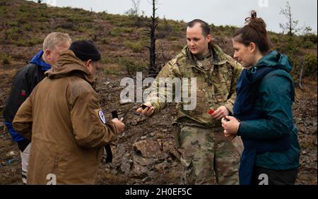 Sgt.Mark Henderson, un soldat de la 702e Compagnie d'Ordnance rattachée à l'équipe de la DOE pour le Commandement régional est, Force du Kosovo, donne des bandes à un membre de l'action antimines Kosovo lors d'une journée de terrain de MAT Kosovo à l'extérieur de Dakovica/Gjakovë, Kosovo, le 11 février 2021.L'équipe de la DOE du RC s'est rendue dans la gamme MAT Kosovo pour renforcer les efforts de coopération entre les organisations militaires et civiles de déminage. Banque D'Images