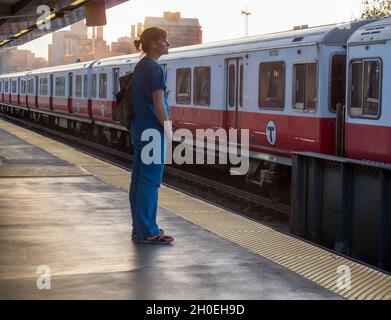 Une infirmière attend un train Redline vers le sud à Charles MGH à Boston, Massachusetts, États-Unis Banque D'Images