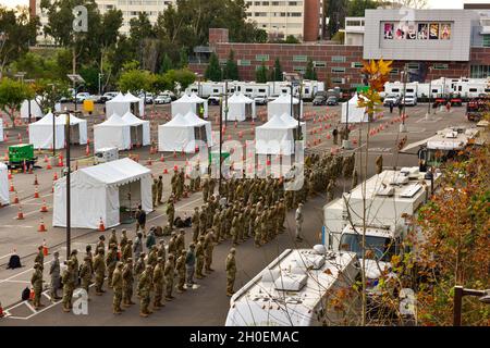 Des gardiens de la Garde nationale de Californie affectés à la Force opérationnelle interarmées Mustang assistent à un briefing du matin sur le campus de l'Université d'État de Californie à Los Angeles, le 15 février 2021.La force a été mise en service pour soutenir le premier site de distribution du vaccin COVID-19 de l’Agence fédérale de gestion des urgences et du Bureau des services d’urgence du gouverneur de la Californie. Banque D'Images