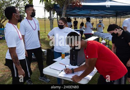 Les bénévoles aident à signer des personnes pour la première course amusante Fat Tuesday 5K à la base aérienne d'Andersen, Guam, le 16 février 2021.Le 5K avait un bloc de temps de trois heures avec une heure de début échelonnée pour ses participants.Chaque individu a dû s'inscrire à des heures de début d'intervalle de 10 minutes avec un maximum de 15 participants dans un intervalle de temps individuel. Banque D'Images