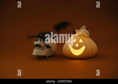 Joyeux Halloween.Crâne avec araignée et citrouille de lanterne sur fond orange avec chauves-souris noires volantes.Arrière-plan de Halloween.Salutation Banque D'Images
