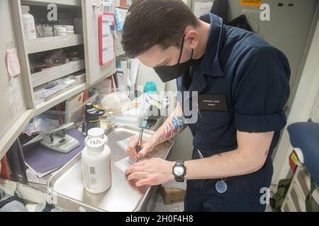 210221-N-FD648-1053 OCÉAN ATLANTIQUE (FÉV21, 2021) -- l'hôpital Corpsman Seaman Chad Backman, d'Utica, New York, remplit les directives pour l'utilisation des médicaments à bord du destroyer de missile guidé de classe Arleigh Burke USS Mahan (DDG 72) le 21 février 2021.Mahan opère dans l'océan Atlantique à l'appui d'opérations navales visant à maintenir la stabilité et la sécurité maritimes afin d'assurer l'accès, de décourager l'agression et de défendre les intérêts des États-Unis, des alliés et des partenaires. Banque D'Images