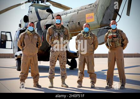 Des pilotes-soldats espagnols affectés à la Force opérationnelle Toro posent pour une photo de groupe devant leurs Airbus Helicopters AS532 Cougars, après avoir transporté l’ambassadeur d’Espagne en Irak, l’honorable Juan Jose Escobar Stemmann, et l’ambassadeur de Pologne en Irak, l’honorable Marcin Kubiak, à la base aérienne d’Al Asad, en Irak, le 21 février 2021.Les ambassadeurs se sont rendus à la base et ont rencontré l'AAAB et le 42e Groupe de soutien régional de la Garde nationale du New Jersey, commandant, le colonel Robert M. Martinez, et ont accueilli leurs soldats respectifs actuellement affectés à la Force opérationnelle Toro et à la Force opérationnelle Minecraft.Les soldats espagnols et polonais en font partie Banque D'Images