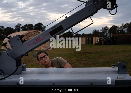 Airman 1re classe Jannah Miran, spécialiste de l'équipement aérospatial du 23e Escadron de maintenance, décompose une tour légère après le lever du soleil le 23 février 2021, à la base aérienne de MacDill, en Floride.Des aviateurs multi-capables affectés à la 23d Wing sont déployés à la base opérationnelle avancée MacDill et à deux emplacements de contingence, la base de la Force spatiale Patrick et la chaîne aérienne Avon Park, pour appuyer les escadrons de génération de mission pour Mosaic Tiger 21-1.Pendant le déploiement simulé, les aviateurs de MacDill mangeaient des repas, étaient prêts à manger et vivaient dans des tentes communautaires. Banque D'Images