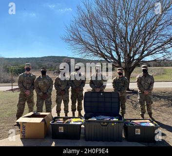 Les soldats de la compagnie Bravo, 303e Bataillon du renseignement militaire, 504e Brigade du renseignement militaire posent pour une photo avec des livres donnés, 23 février 2021, fort Hood, Texas.Un duo composé d'un frère et d'une sœur a organisé le don pour sensibiliser les gens à la santé mentale et au suicide. Banque D'Images