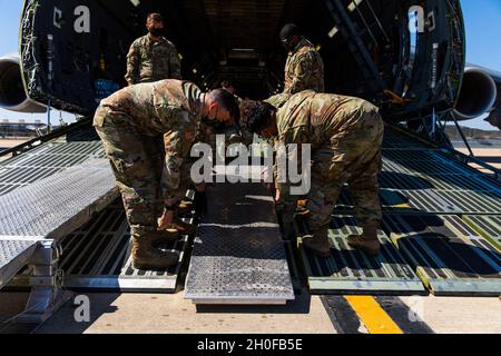 Des soldats et des aviateurs du 3e Bataillon, du 227e Régiment d'aviation, de la 1re Brigade de cavalerie aérienne, de la 1re Division de cavalerie et du 621e Escadron d'opérations de soutien à la mobilité ont travaillé ensemble pour installer la rampe de transport de L'UH-60 Black Hawk dans l'aéronef Lockheed C-5 Galaxy à fort Hood, Texas, le 24 février 2021.Les soldats et les aviateurs doivent installer un total de 3 rampes pour chaque roue qui se trouve sur le Black Hawk afin de s'assurer qu'elle pénètre dans le C-5 en toute sécurité. Banque D'Images