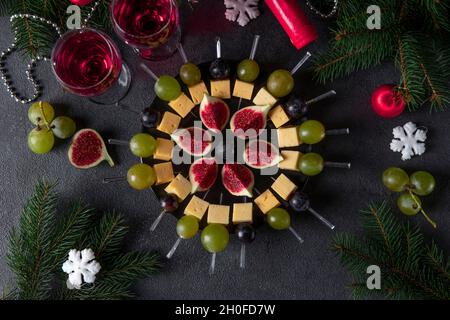 Canapés au fromage, raisins et figues.En-cas de fête pour le vin sur fond sombre Banque D'Images