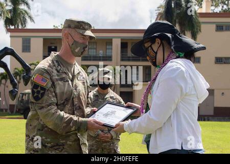 Le colonel Josh Bookout, équipe de combat de la 3e Brigade d'infanterie, commandant de la 25e Division d'infanterie, présente la membre de la famille Gold Star, Mme Jennifer Ray, un certificat d'appréciation à l'extérieur du quartier général de la brigade lors de sa visite à la caserne Schofield, à Hawaï, le 25 février 2021.Mme Ray est la sœur du 1er Lt Clovis T. Ray, un chef de peloton de carabine affecté au 2e Bataillon, 35e Régiment d'infanterie lorsqu'il est mort de blessures subies lors d'une attaque ennemie à l'aide d'un engin explosif improvisé (IED) alors qu'il était en patrouille dans la vallée de la rivière Pech, dans la province de Kunar,Afghanistan le 15 mars 2012. Banque D'Images