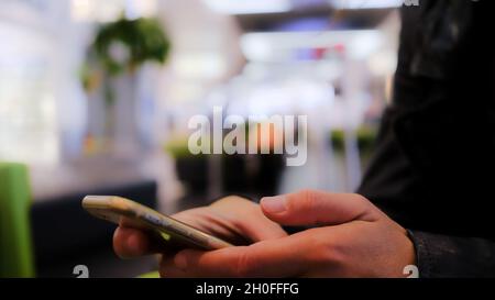 femme mains avec le téléphone à l'aéroport. chat, appel vidéo, social. Banque D'Images