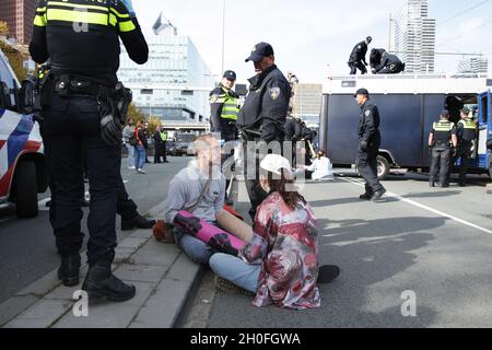La police néerlandaise anti-émeute arrête l'extinction les activistes climatiques de la rébellion bloquent la route lors d'une manifestation près de la gare centrale le 11 octobre 2021 dans le Hag Banque D'Images