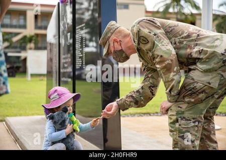 Le colonel Josh Bookout, équipe de combat de la 3e Brigade d'infanterie, commandant de la 25e Division d'infanterie, présente les enfants de la membre de la famille Gold Star, Mme Jennifer Ray, une pièce de monnaie de brigade à l'extérieur du quartier général de la brigade lors de leur visite à la caserne Schofield, à Hawaï, le 25 février 2021.Mme Ray est la sœur du 1er Lt Clovis T. Ray, un chef de peloton de carabine affecté au 2e Bataillon, 35e Régiment d'infanterie lorsqu'il est mort de blessures subies lors d'une attaque ennemie à l'aide d'un engin explosif improvisé (IED) alors qu'il était en patrouille dans la vallée de la rivière Pech, dans la province de Kunar,Afghanistan le 15 mars 2012. Banque D'Images