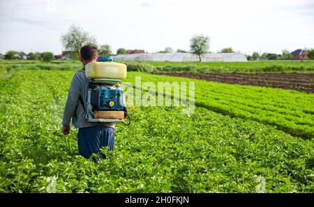 Oblast de Kherson, Ukraine - 22 mai 2021 : un agriculteur pulvérise des pesticides dans les plantations.Utiliser des produits chimiques pour protéger les plantes contre les insectes et les infections fongiques. Banque D'Images