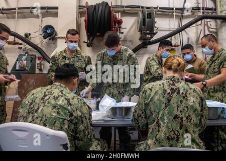 SASEBO, Japon (fév26, 2021) les marins affectés au navire d’assaut amphibie déployé à l’avant USS America (LHA 6) remplissent les seringues du vaccin Moderna COVID-19 dans la zone d’arrimage du véhicule du navire.L'Amérique, navire chef de file de l'America Amphiobie Ready Group, ainsi que la 31e unité expéditionnaire maritime, opère dans la zone de responsabilité de la 7e flotte des États-Unis pour améliorer l'interopérabilité avec les alliés et les partenaires et servir de force de réponse prête à l'emploi pour défendre la paix et la stabilité dans la région Indo-Pacifique. Banque D'Images