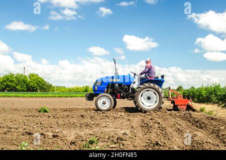 Oblast de Kherson, Ukraine - 28 mai 2020 : un agriculteur sur un tracteur travaille dans le champ et élève la poussière.Labourage dans le champ.Utilisation de machines agricoles et à Banque D'Images