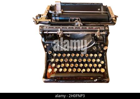 Une vieille machine à écrire rétro avec clavier espagnol sur un bureau en bois, isolée sur fond blanc Banque D'Images