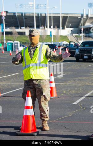 Pvt. Armée américaineJoseph Black, soldat du 1er Bataillon, 144e Régiment d'artillerie de campagne, Garde nationale de Californie, dirige les récipiendaires du COVID-19 dans le parking du Coliseum d'Oakland, Oakland, Californie, 26,2021 février.La Cal Guard, ainsi que d’autres agences fédérales et d’État, soutiennent pleinement la volonté du gouverneur d’envoyer le vaccin COVID-19 à autant de Californiens Dès que possible. Banque D'Images