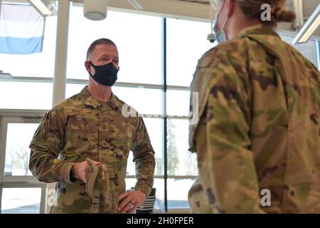 Le général de division Rich Neely de la Force aérienne des États-Unis, l'adjudant général de l'Illinois et commandant de la Garde nationale de l'Illinois, parle au SPC de l'armée américaine.Chelsey Nimon, 634e Bataillon de soutien de brigade, membre du combat dans un site de vaccin COVID-19 du comté de Cook, Illinois, le 26 février 2021.Nimon a plus tard reçu une pièce de monnaie décorative offerte par le général Neely comme son appréciation pour sa performance exceptionnelle pendant qu'il était dans la ligne de service. Banque D'Images