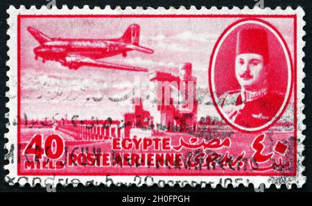 ÉGYPTE - VERS 1947 : un timbre imprimé en Égypte montre le roi Farouk, le barrage Delta et l'avion DC-3, vers 1947 Banque D'Images