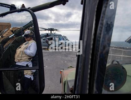 210226-N-NQ285-1200 OCÉAN ATLANTIQUE (FÉV26, 2021) l'hôpital Corpsman de 1re classe Eric Lewis, de Pensacola, en Floride et affecté au navire d'atterrissage de la classe Harpers Ferry USS carter Hall (LSD 50), fournit une couverture médicale pendant un transfert de personnel dans un hélicoptère MH-60S Sea Hawk, affecté aux « Chargers » de l'Escadron de combat de la mer (HSC) 26,Sur le pont de vol du navire, le 26 février 2021.Carter Hall mène une formation avec l'escadron amphibie 4 et la 24e unité expéditionnaire maritime (24e unité MEU) dans le cadre du Groupe de prêt amphibie Iwo Jima. Banque D'Images