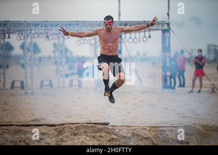 Un participant à la course de Spartan d'Okinawa saute au-dessus d'une fosse à feu sur la plage de Chura Sun, Okinawa, Japon, le 27 février 2021.Okinawa a organisé sa toute première course Spartan, attirant plus de 2,000 concurrents pour se lancer dans des courses remplies de plus de 20 obstacles, notamment des haies, des chenilles basses dans le sable, des lancers de javelin, des haltérophilie et de l'escalade.Créée pour la première fois à Pittsfield, dans le Vermont, en 2010, la course Spartan attire maintenant plus de 1.5 millions de participants chaque année et est établie dans plus de 40 pays dans le monde entier. Banque D'Images