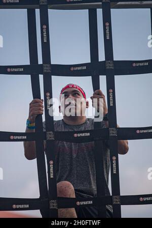 Un participant à la course de Spartan d'Okinawa met à l'échelle un obstacle à la corde sur la plage de Chura Sun, Okinawa, Japon, le 27 février 2021.Okinawa a organisé sa toute première course Spartan, attirant plus de 2,000 concurrents pour se lancer dans des courses remplies de plus de 20 obstacles, notamment des haies, des chenilles basses dans le sable, des lancers de javelin, des haltérophilie et de l'escalade.Créée pour la première fois à Pittsfield, dans le Vermont, en 2010, la course Spartan attire maintenant plus de 1.5 millions de participants chaque année et est établie dans plus de 40 pays dans le monde entier. Banque D'Images